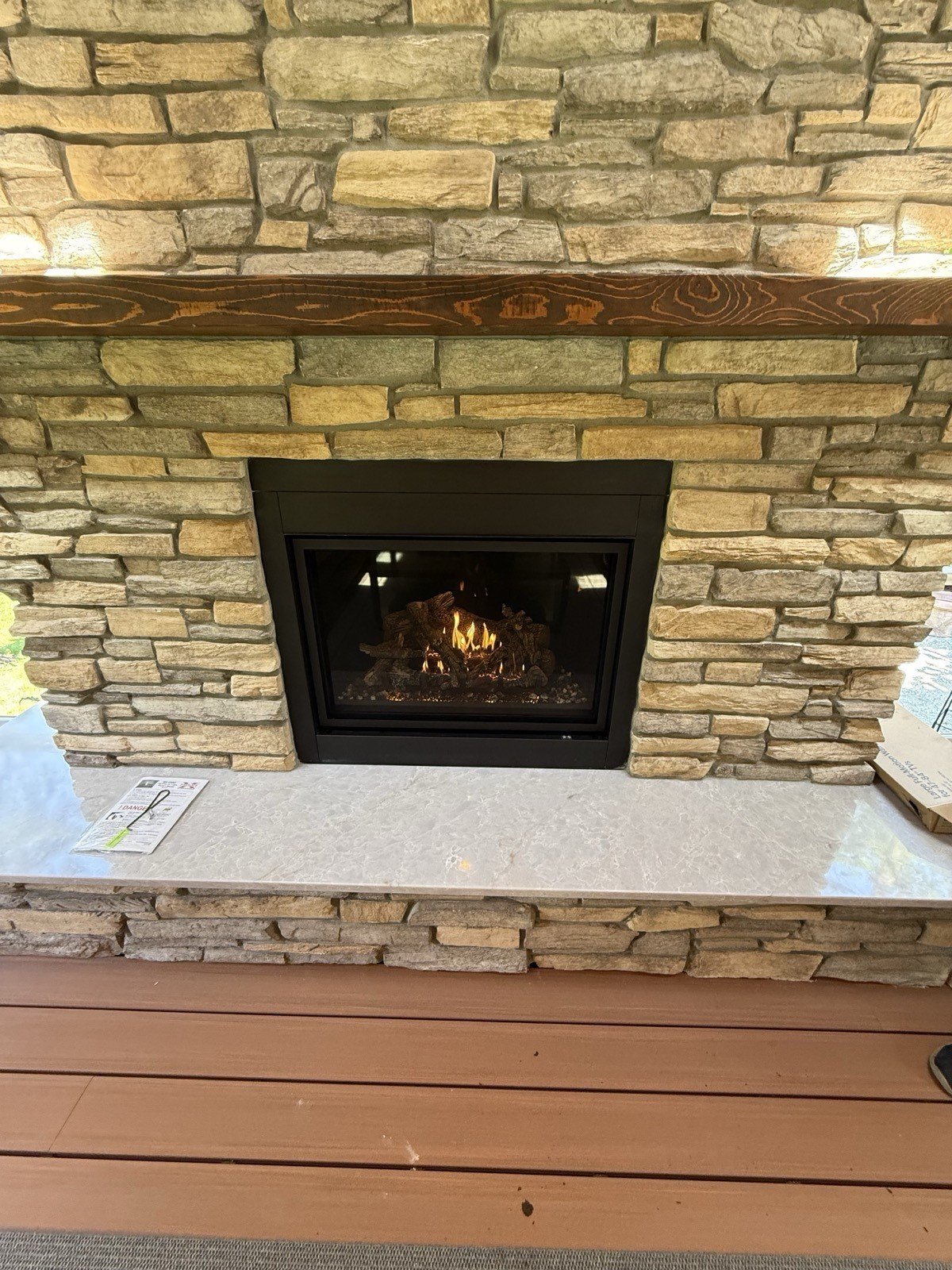 Custom stacked-stone fireplace surround with gas fireplace insert